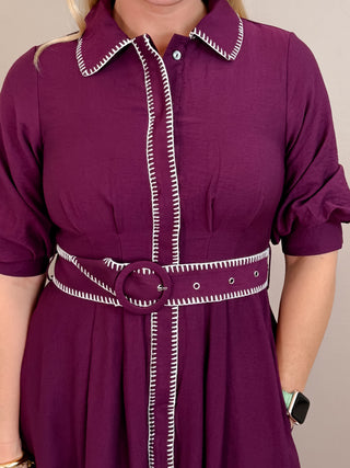 Solid short puff sleeve midi dress featuring contrast embroidered blanket stitch trim and removable belt at waist. Button closure at front. Side pockets. Lined. Woven. Non-sheer. Lightweight.