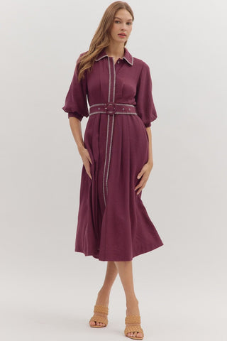 Solid short puff sleeve midi dress featuring contrast embroidered blanket stitch trim and removable belt at waist. Button closure at front. Side pockets. Lined. Woven. Non-sheer. Lightweight.